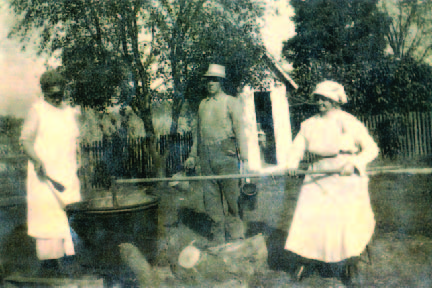 Early photo of family making apple butter over a fire