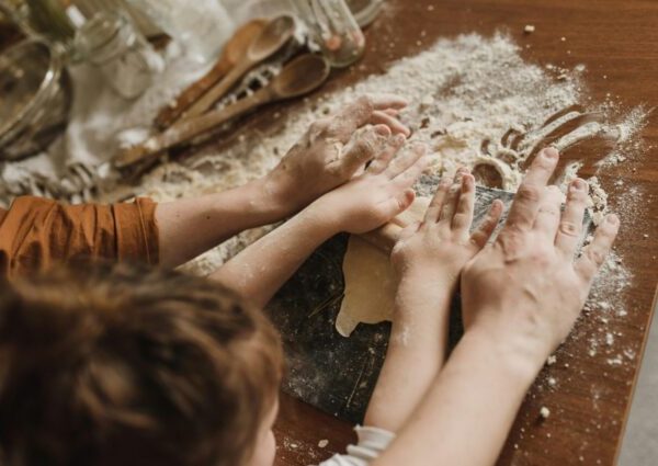 adult and child rolling out dough together