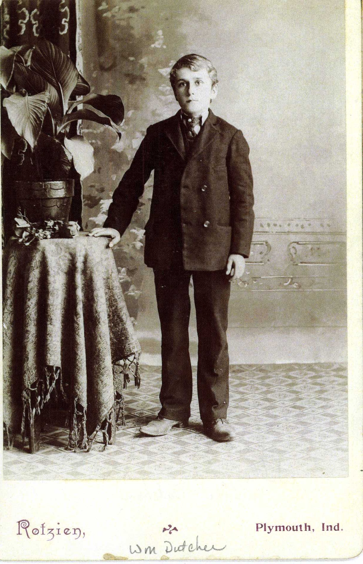 Young boy posing for image with hand on table
