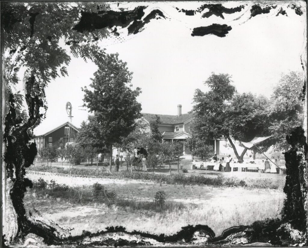 People standing in front of house and barn
