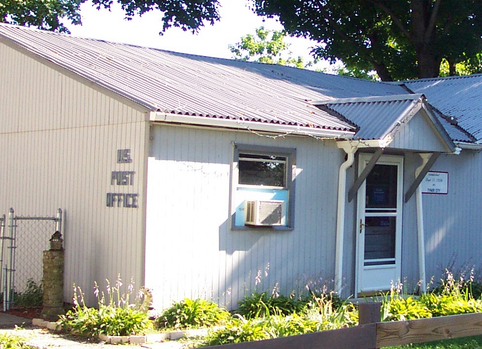 Large group of people standing around statue of Chief Menominee
